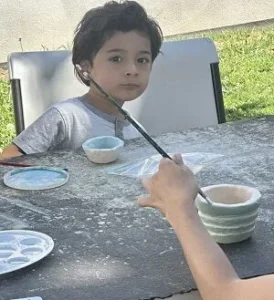 Painting a small ceramic bowl during a pottery class