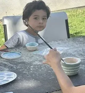 Painting a small ceramic bowl during a pottery class